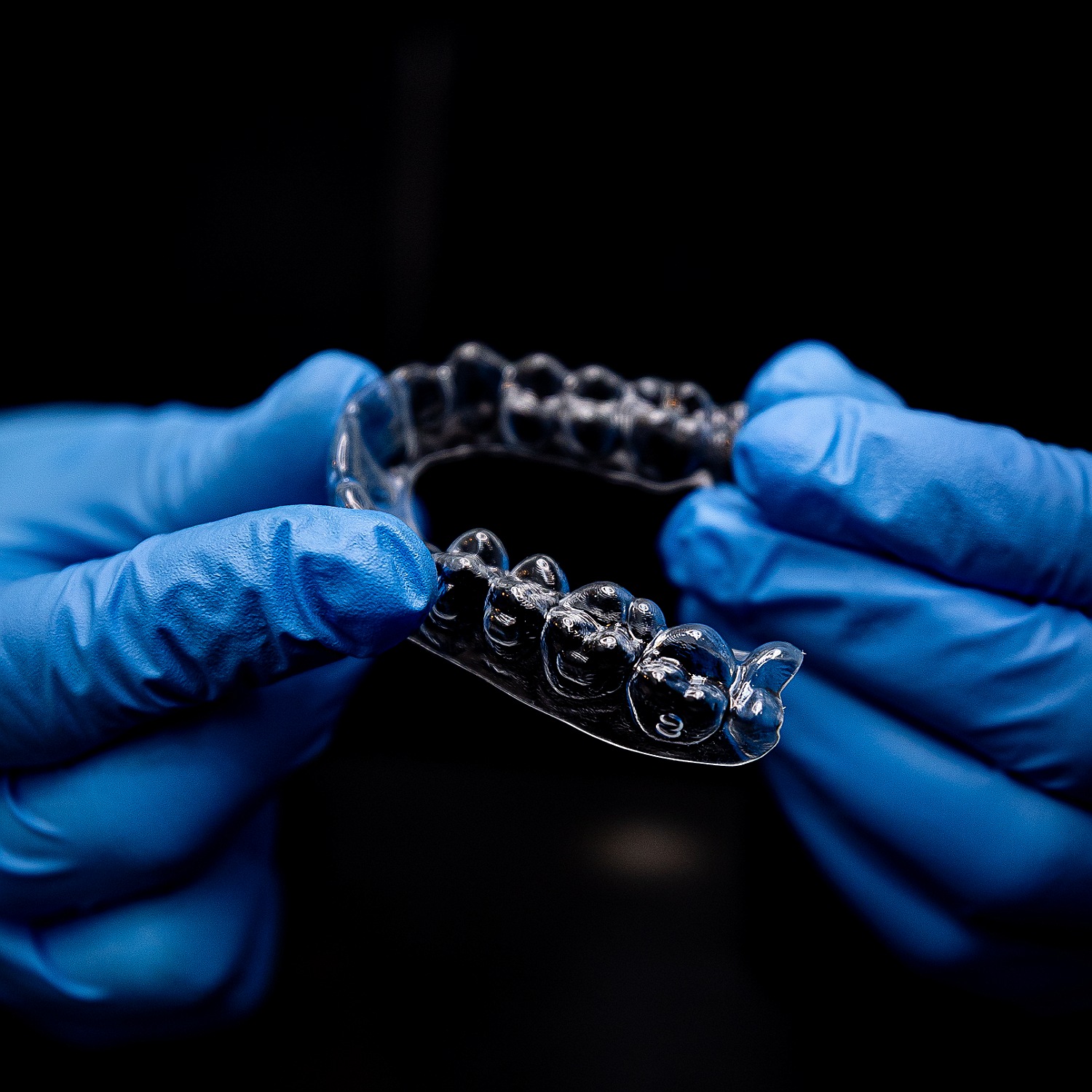 Clinician holding a clear ARC aligner